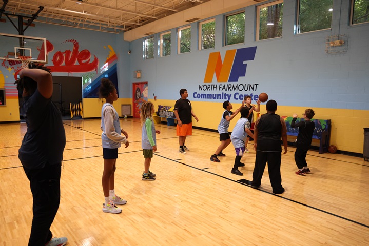 A group of students playing basketball in their Community Center.