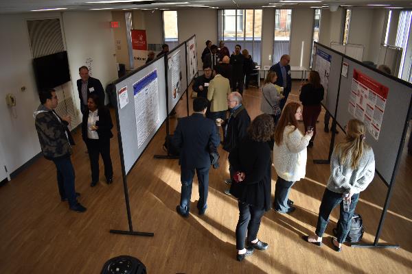people viewing posters in a conference space