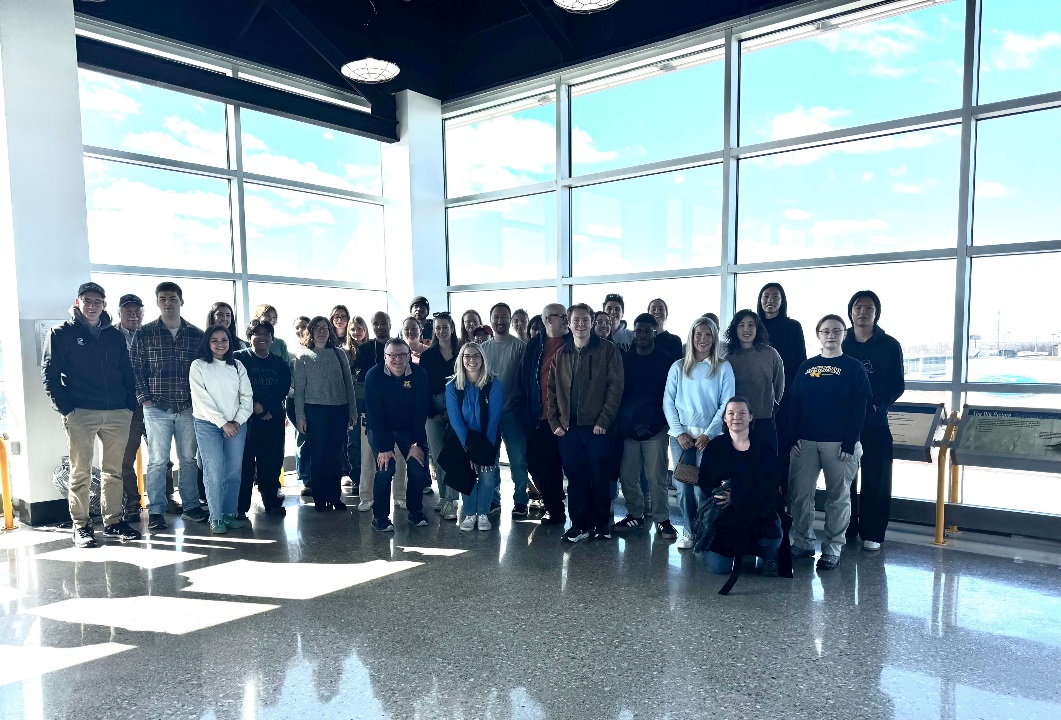 Group of people standing in front of large windows