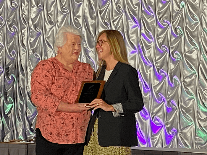two people on stage presenting an award