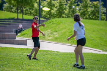 students playing frisbee on campus