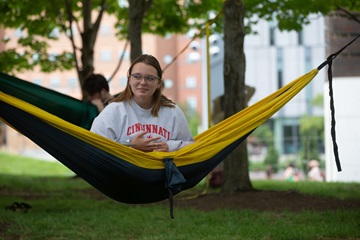 student relaxing in hammock on campus
