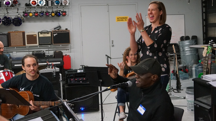 woman clapping with people creating music