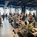 Group of people learning to cook at food stations