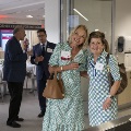 Two women post with others in the background mingling