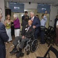 Two men pose for a picture with others guests mingling