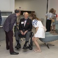 Seated man speaking to two people with others in the background