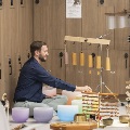A man performs sound immersion surrounded by instruments