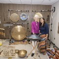 Two women pose surrounded by sound immersion instruments