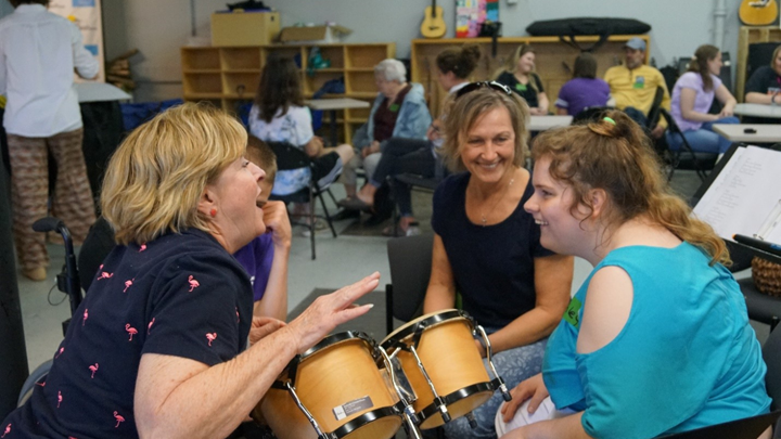 women sitting in a group creating music