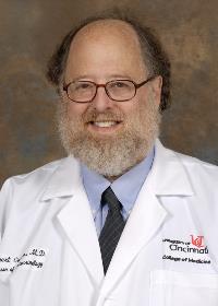 Gentleman with beard and glasses dressed in white medical coat